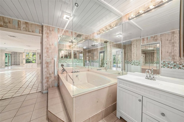 bathroom featuring a washtub, vanity, wooden walls, and tile patterned flooring