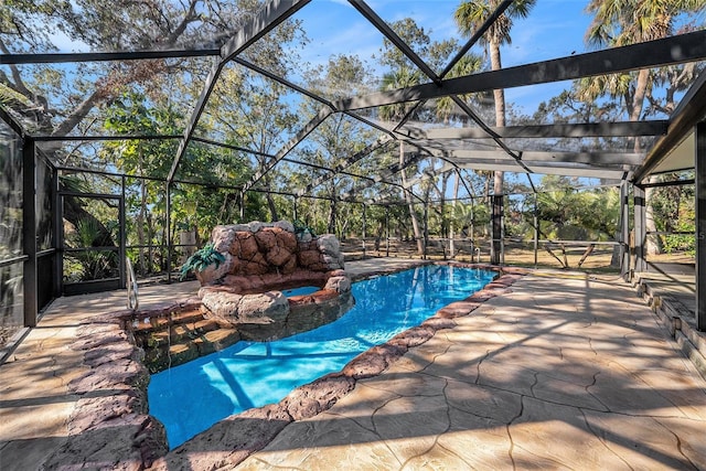 view of pool with glass enclosure and a patio area