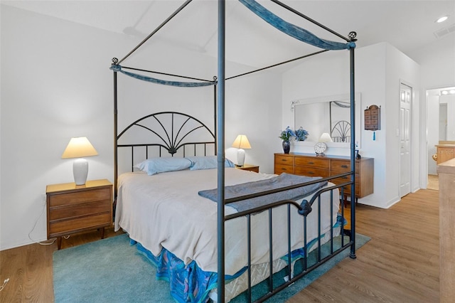 bedroom featuring hardwood / wood-style floors and ensuite bath