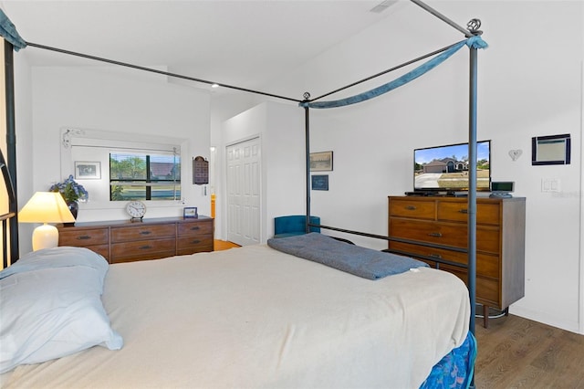 bedroom with dark hardwood / wood-style floors and a closet