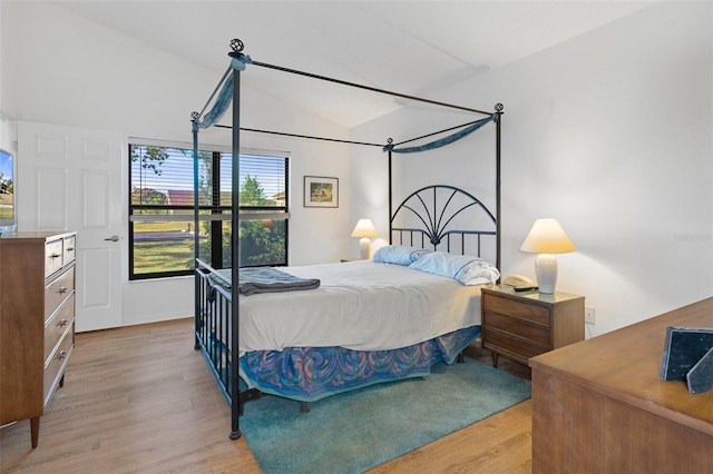 bedroom featuring light hardwood / wood-style floors and lofted ceiling