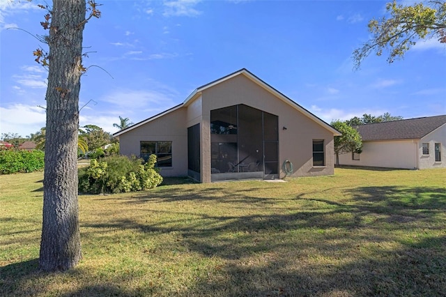 rear view of house with a sunroom and a yard