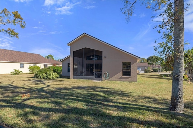 back of house featuring a lawn and a sunroom