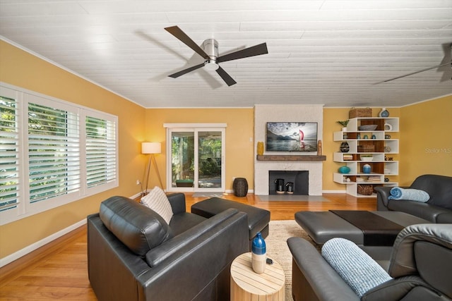 living room with crown molding, ceiling fan, and light hardwood / wood-style floors