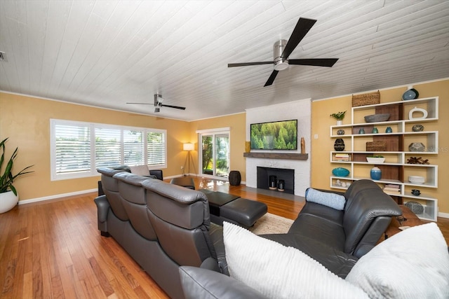 living room with a fireplace, light hardwood / wood-style flooring, ceiling fan, and wooden ceiling