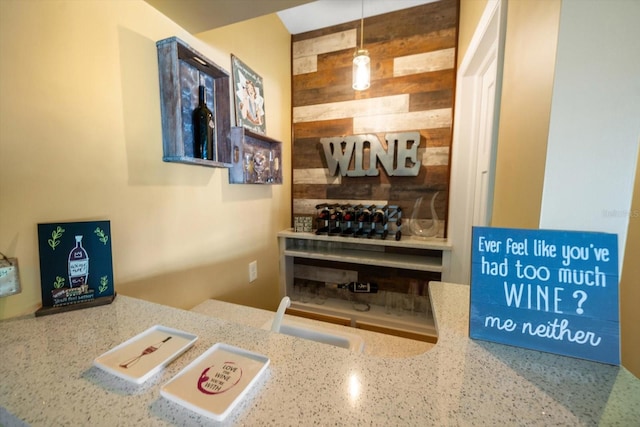 bar with decorative light fixtures, decorative backsplash, and light stone countertops