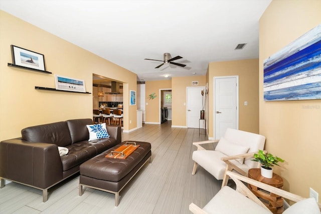 living room with ceiling fan and light hardwood / wood-style flooring