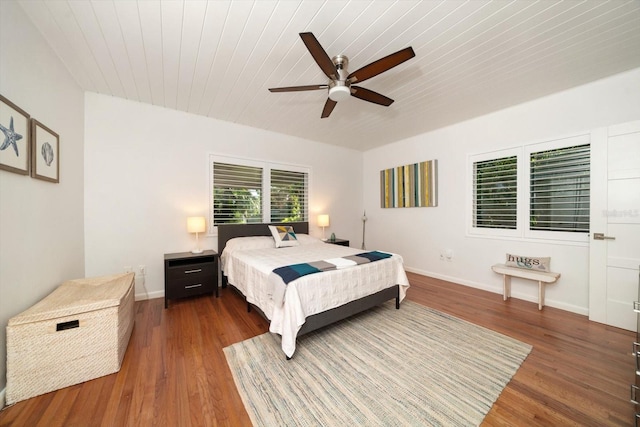 bedroom with dark hardwood / wood-style floors, ceiling fan, and wooden ceiling