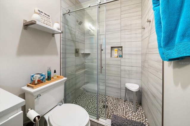 bathroom with toilet and a shower with shower door