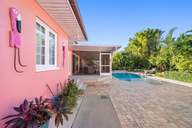 view of pool featuring a patio area and a sunroom