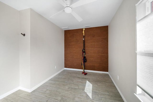 spare room with ceiling fan and wood walls