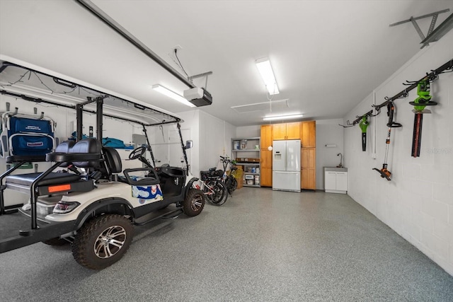 garage featuring a garage door opener and white fridge with ice dispenser