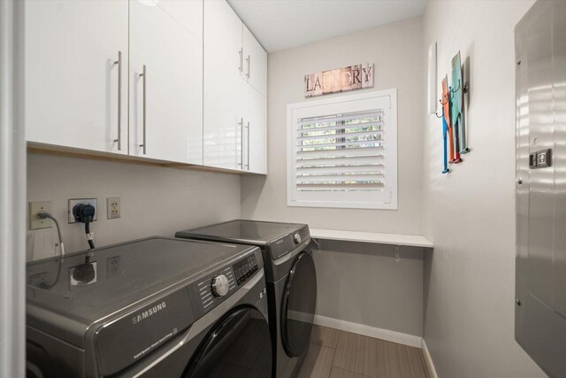 laundry area featuring washing machine and clothes dryer and cabinets