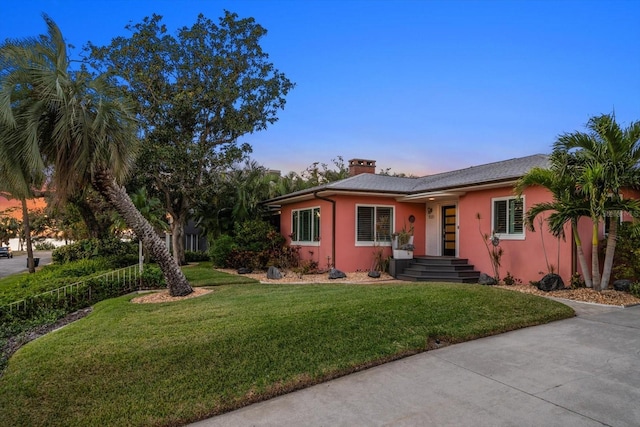 ranch-style home featuring a lawn