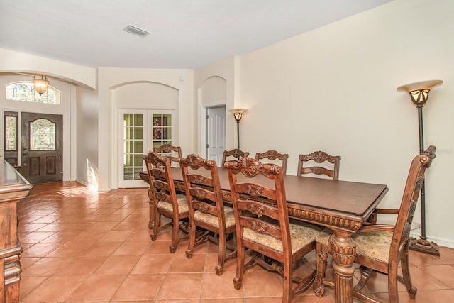 dining space featuring french doors and light tile patterned floors