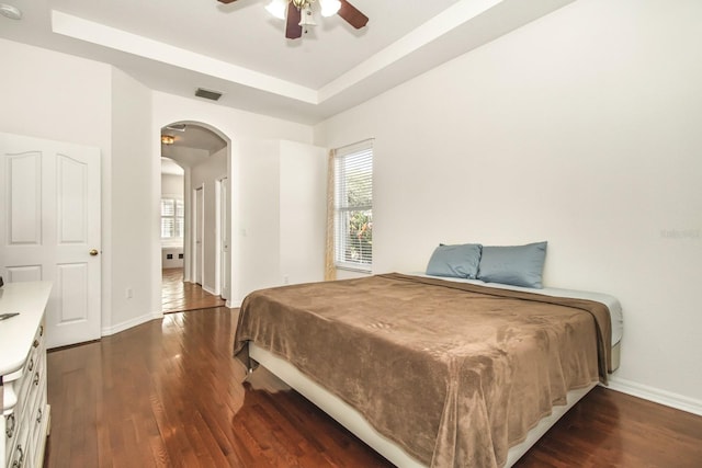 bedroom featuring a tray ceiling, ceiling fan, dark hardwood / wood-style flooring, and billiards