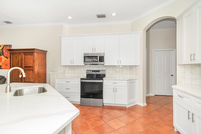 kitchen featuring backsplash, white cabinetry, sink, and stainless steel appliances