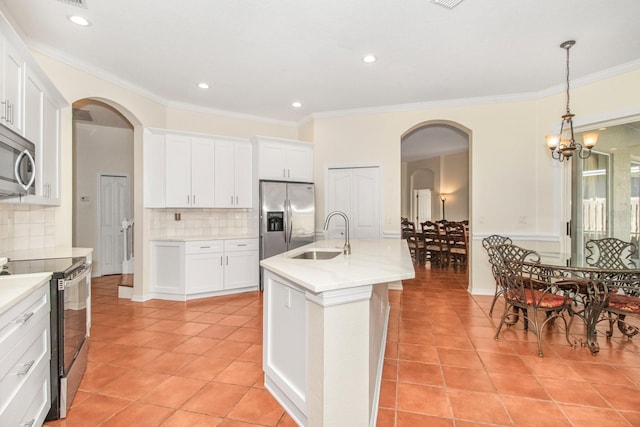 kitchen with sink, white cabinets, stainless steel appliances, and a notable chandelier