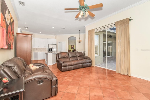 tiled living room featuring ceiling fan with notable chandelier and crown molding