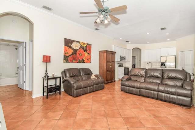 living room with crown molding, sink, light tile patterned flooring, and ceiling fan