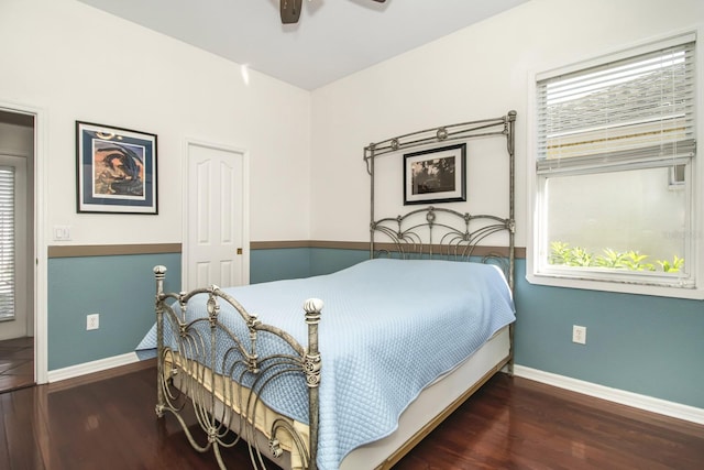 bedroom with ceiling fan, dark wood-type flooring, and multiple windows