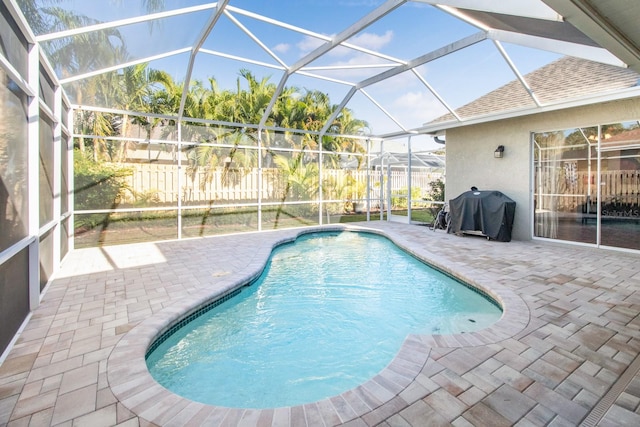 view of swimming pool featuring a lanai, area for grilling, and a patio