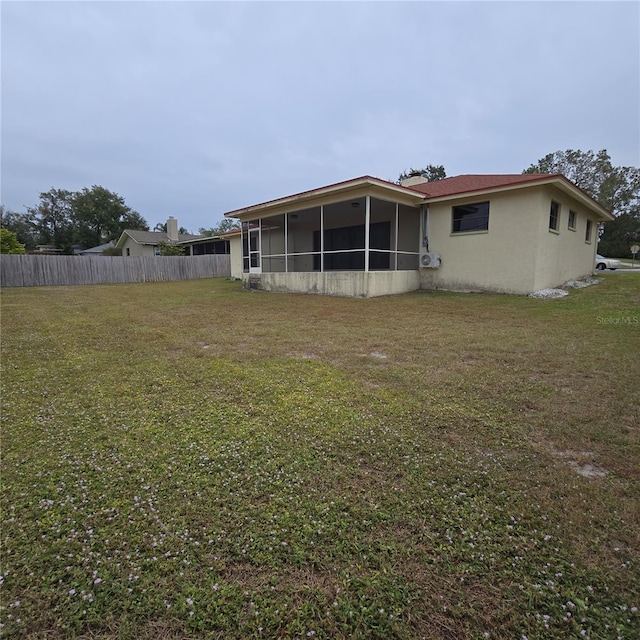 back of property with a yard and a sunroom