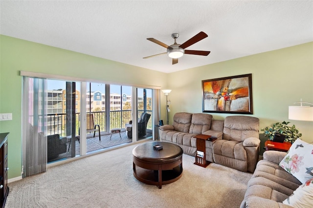 living room featuring carpet, ceiling fan, and a textured ceiling