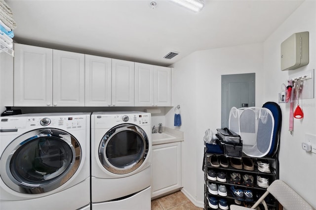 clothes washing area with sink, cabinets, electric panel, washer and clothes dryer, and light tile patterned flooring