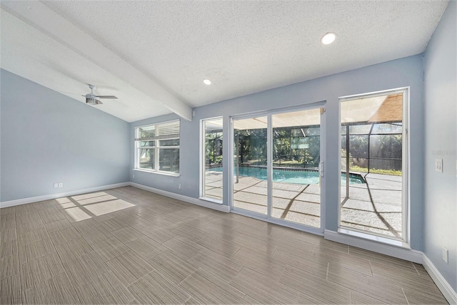 spare room with hardwood / wood-style floors, ceiling fan, a textured ceiling, and a wealth of natural light