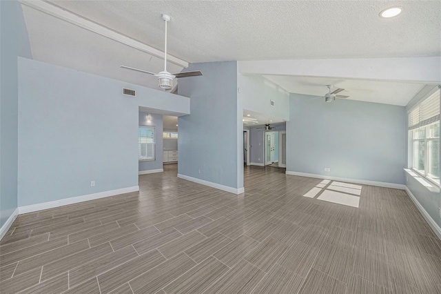 unfurnished living room featuring lofted ceiling with beams, ceiling fan, wood-type flooring, and a textured ceiling