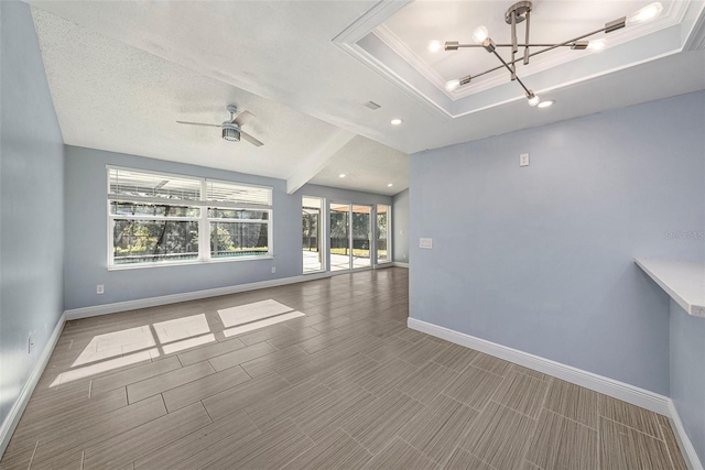 unfurnished living room with crown molding, a textured ceiling, a tray ceiling, ceiling fan with notable chandelier, and hardwood / wood-style flooring