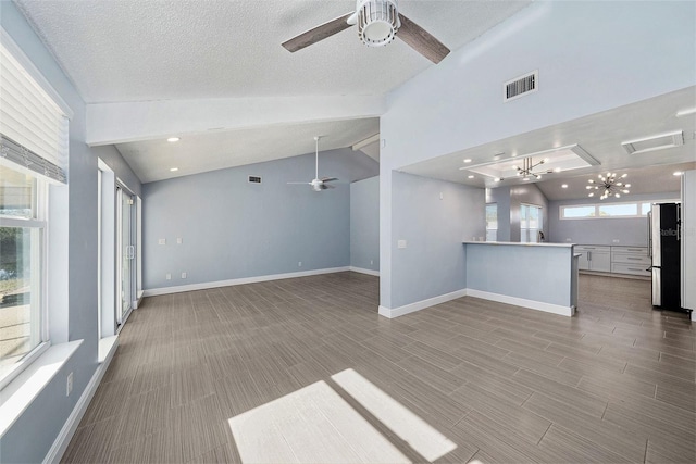 unfurnished living room featuring hardwood / wood-style flooring, ceiling fan, a textured ceiling, and vaulted ceiling