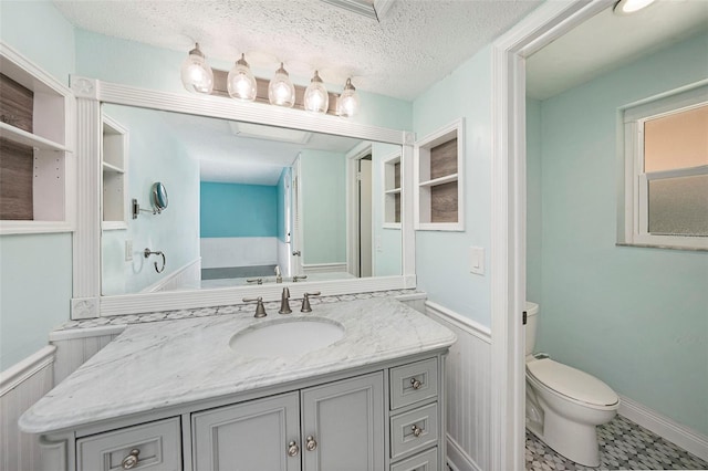 bathroom with a bath, tile patterned floors, a textured ceiling, toilet, and vanity