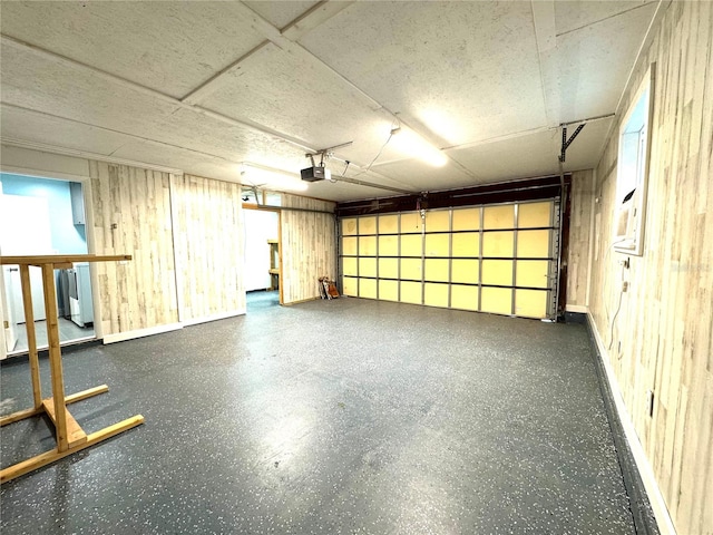 garage with wood walls and a garage door opener