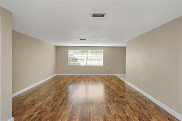 spare room featuring dark hardwood / wood-style flooring