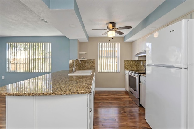 kitchen featuring white cabinets, plenty of natural light, white refrigerator, and stainless steel range with electric cooktop