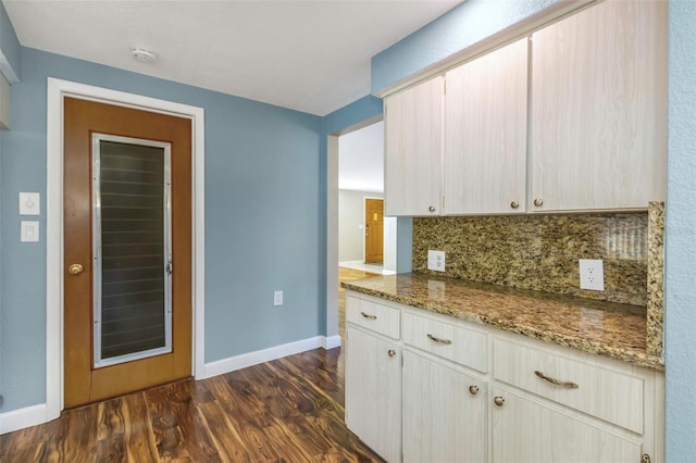 kitchen featuring dark hardwood / wood-style floors, light brown cabinetry, stone counters, and tasteful backsplash