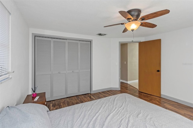 bedroom featuring ceiling fan, dark wood-type flooring, and a closet