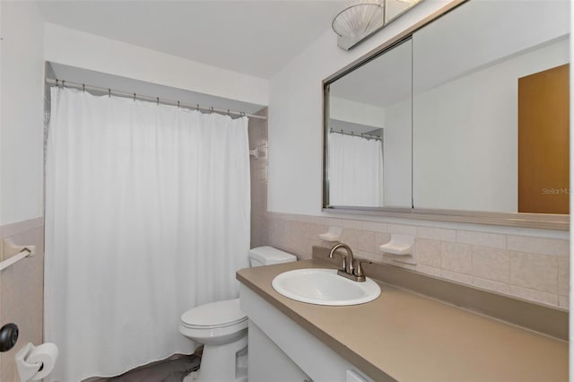 bathroom featuring vanity, tasteful backsplash, toilet, and tile walls