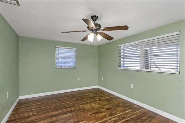 unfurnished room featuring ceiling fan, dark wood-type flooring, and a textured ceiling