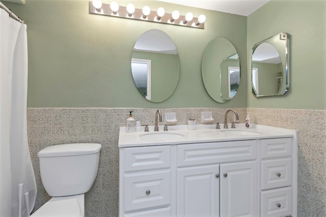 bathroom with vanity, toilet, and tile walls