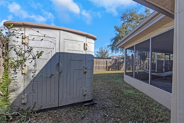 view of outbuilding featuring a sunroom and a yard