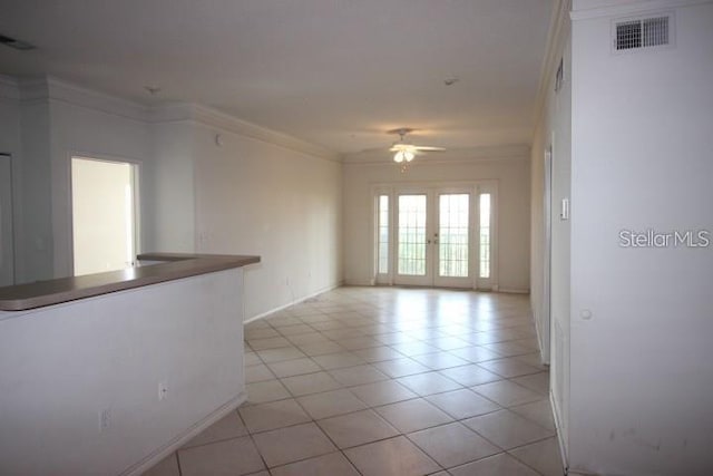 spare room with light tile patterned floors, ceiling fan, french doors, and crown molding