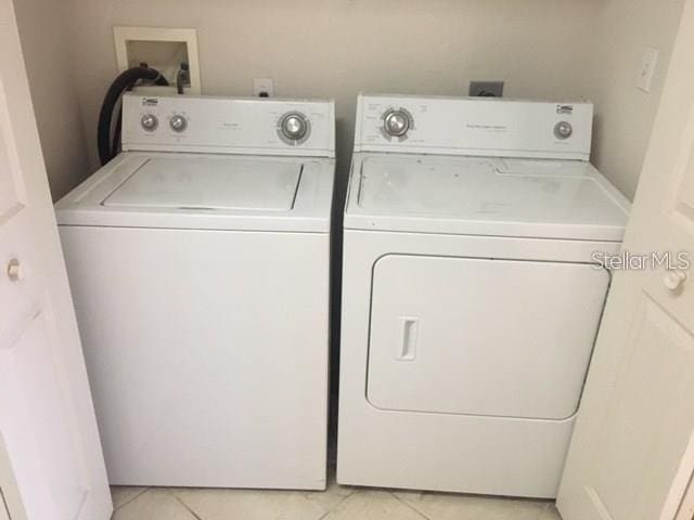 laundry area with light tile patterned flooring and washing machine and clothes dryer