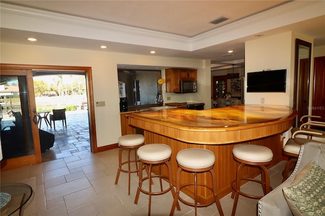 bar with ornamental molding, sink, and wooden counters