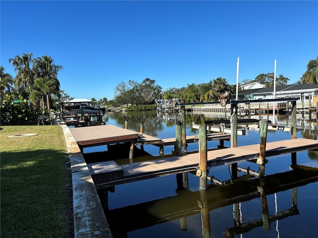 dock area featuring a lawn and a water view