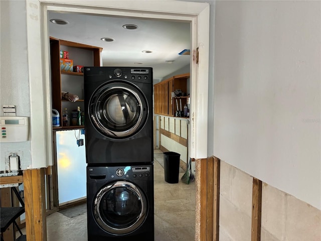 clothes washing area with stacked washer and dryer