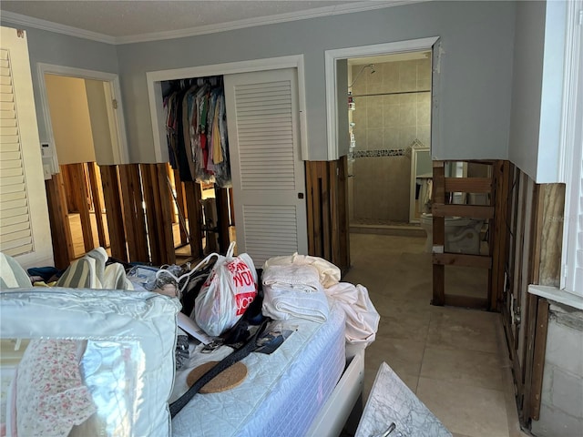 bedroom with light tile patterned floors, a closet, and crown molding