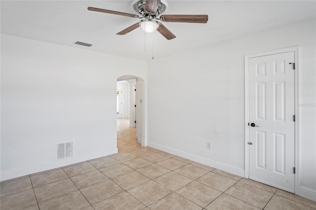 tiled spare room featuring ceiling fan